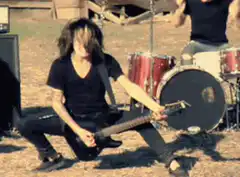 guitarist playing guitar on ground