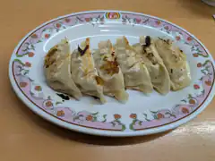 pan-fried dumplings on floral plate