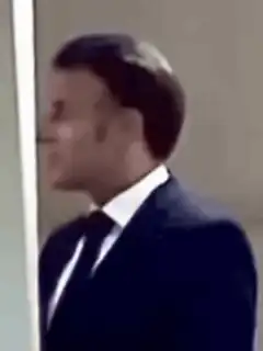 Emmanuel Macron turns and smiles