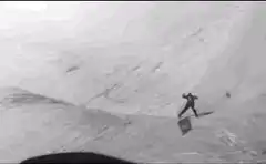 vintage skier jumping down a snowy slope