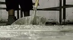 Person shoveling and scooping white goo
