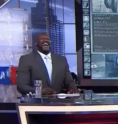 Shaquille O'Neal laughing and throwing papers
