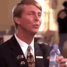 Man in suit drinking water