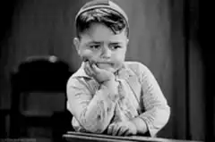 Sad little boy resting his head on his hand