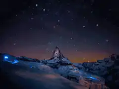 Starry night over snowy mountains