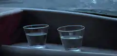 Two plastic cups of water in a car