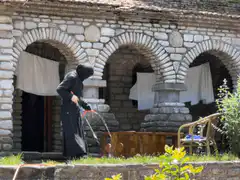 Woman in black dress watering plants