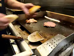 Chef toasting burger buns on griddle