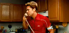 Brad Pitt in red shirt on phone