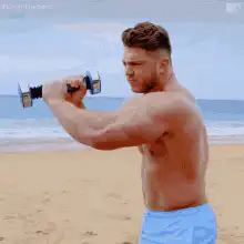 Man lifting dumbbell on beach