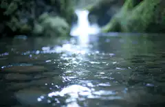 Close-up of a stream with a waterfall in the background