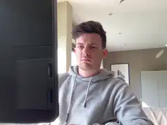 man in grey hoodie looking at computer