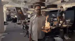 Man stands calmly in chaotic office