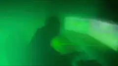 Hacker typing with green laser beams