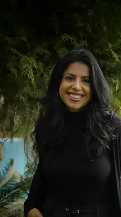 Woman smiling outdoors near trees