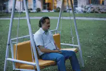 Man on swing, pregnant woman, empty pool