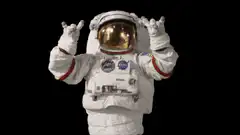 Astronaut making rock on hand gesture