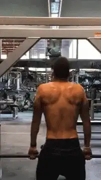 Muscular man doing pull-ups in gym