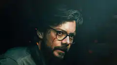 Man with glasses and mustache in dark room