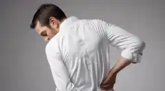 man holding lower back in pain