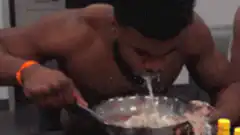 shirtless man eating cereal messily