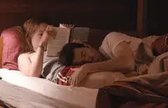 woman reading while man sleeps