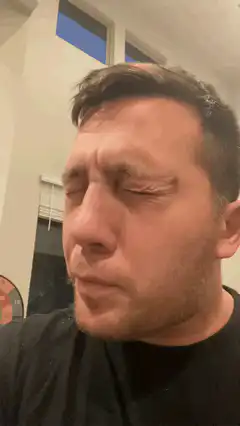 man squinting and waving