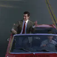 Mr. Bean waving from a convertible