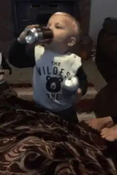 Baby drinking from two cans