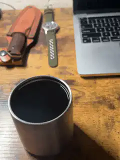 metal cup on wooden desk