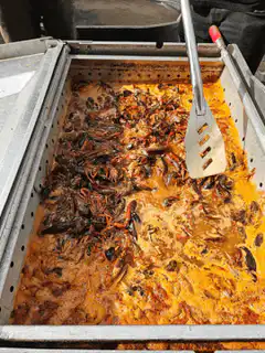 Stirring a large pot of cooked crabs