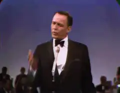 Frank Sinatra conducting with a microphone