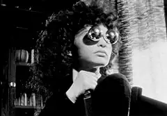 Woman with round glasses holding a knife