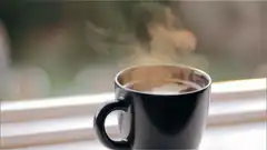 steaming black coffee mug on windowsill