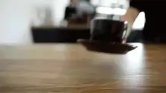 Various people placing coffee cups on tables