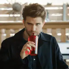 Man drinking red drink with straw
