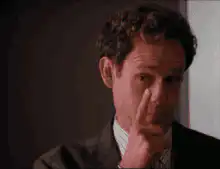 Man touching nose with finger