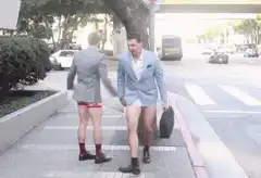 Two men in suits run with no pants