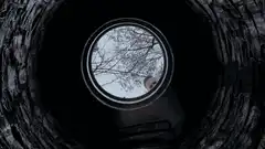 Two men looking down a dark well