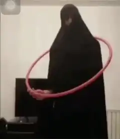 Woman in black niqab hula hooping
