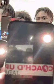 Group of men holding up phones with flashlights on