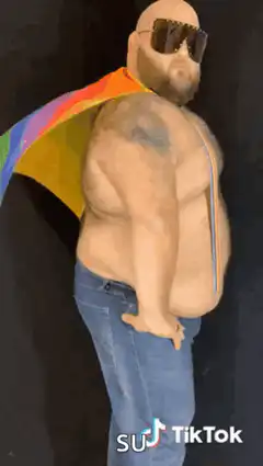 Bald man with rainbow cape and sunglasses