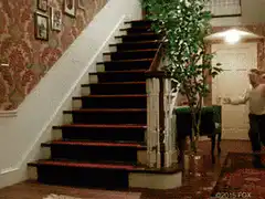 Man runs up stairs and down hallway