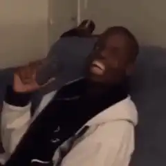 Man laughing hysterically on couch