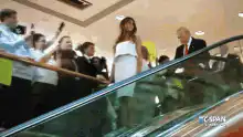 Donald Trump waves on escalator