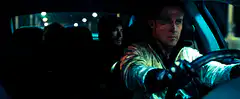Ryan Gosling driving at night with a cigarette