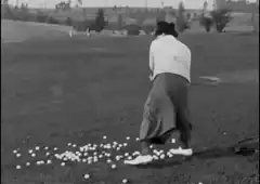 man swinging golf club at driving range