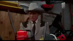 Man in cowboy hat surrounded by chainsaws