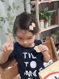 Toddler eating cracker says no