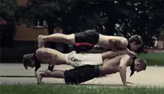 three men doing human pyramid pushups